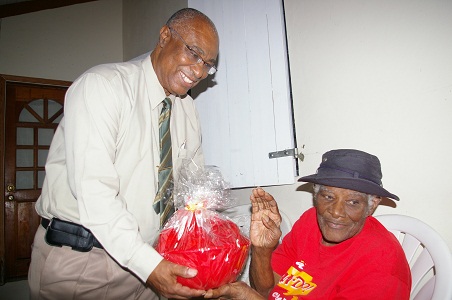 Premier Parry giving a gift basket to Mrs. Rose Martin of Jessups village on his 25th anniversary of elected office